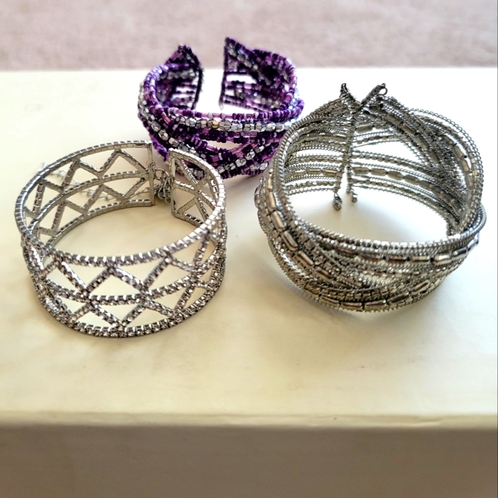 3 fashion bracelets. Two silver, one purple